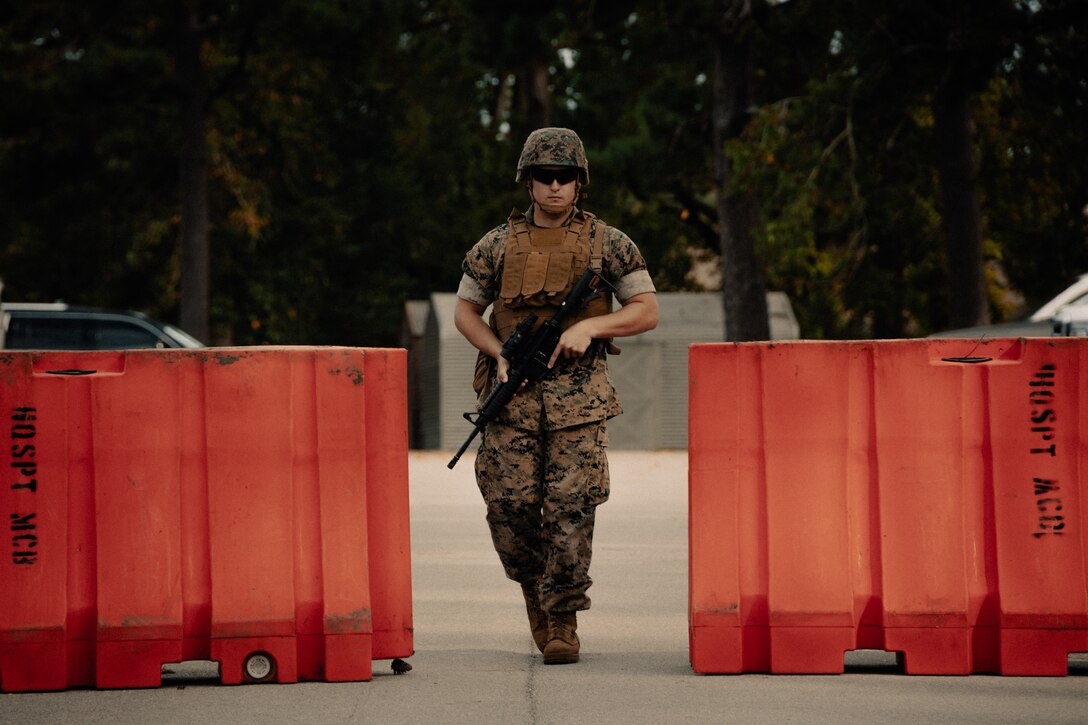 U.S. Marine Corps Lance Cpl. Hayden Rife, engineer assistant, Headquarters and Support (H&S) Battalion, Marine Corps Installations East, stands guard at a barricade during Exercise Urgent Response on Marine Corps Base Camp Lejeune, North Carolina, Sept. 15, 2022. H&S Battalion Marines conducted identification checks and established vehicle control points in support of Exercise Urgent Response, an installation-wide exercise that plans for and executes anti-terrorism response procedures. (U.S. Marine Corps photo by Lance Cpl. Zachary Zephir)
