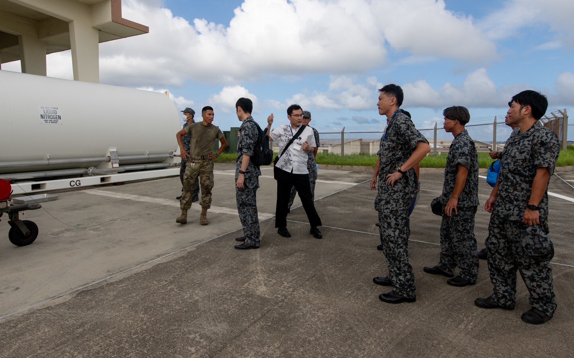A group of U.S. and Japanese service members discuss cryogenics operations.