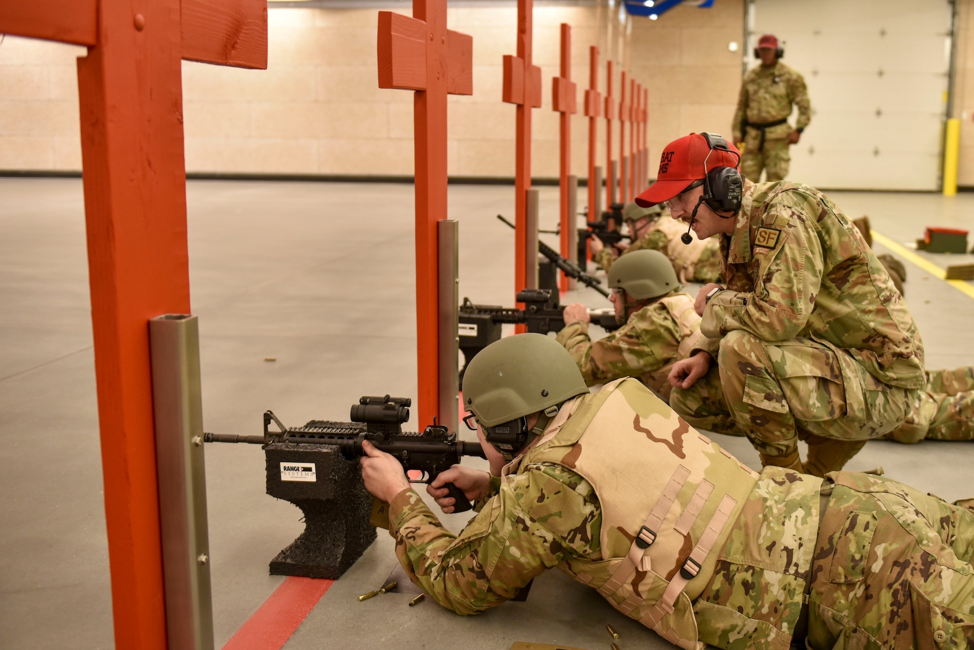 Airmen lay down in prone position to prepare for shooting an M4 Carbine rifle.