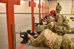 Airmen lay down in prone position to prepare for shooting an M4 Carbine rifle.