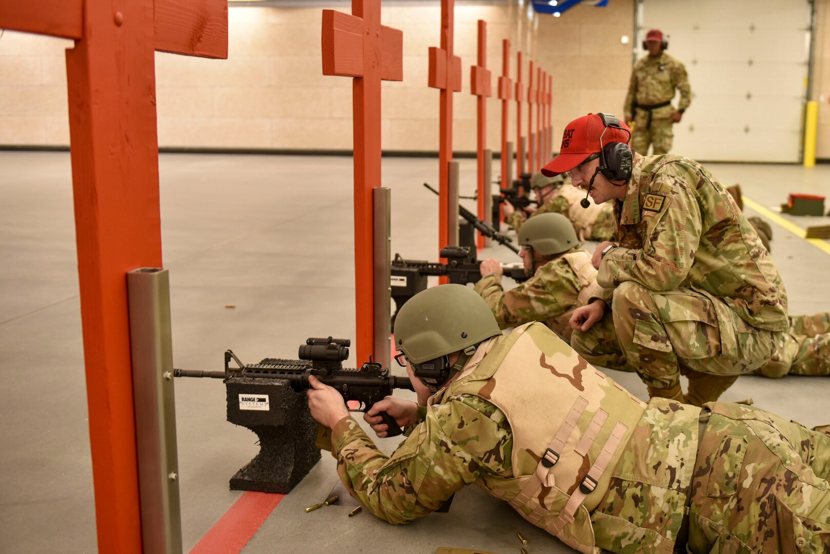 Airmen lay down in prone position to prepare for shooting an M4 Carbine rifle.