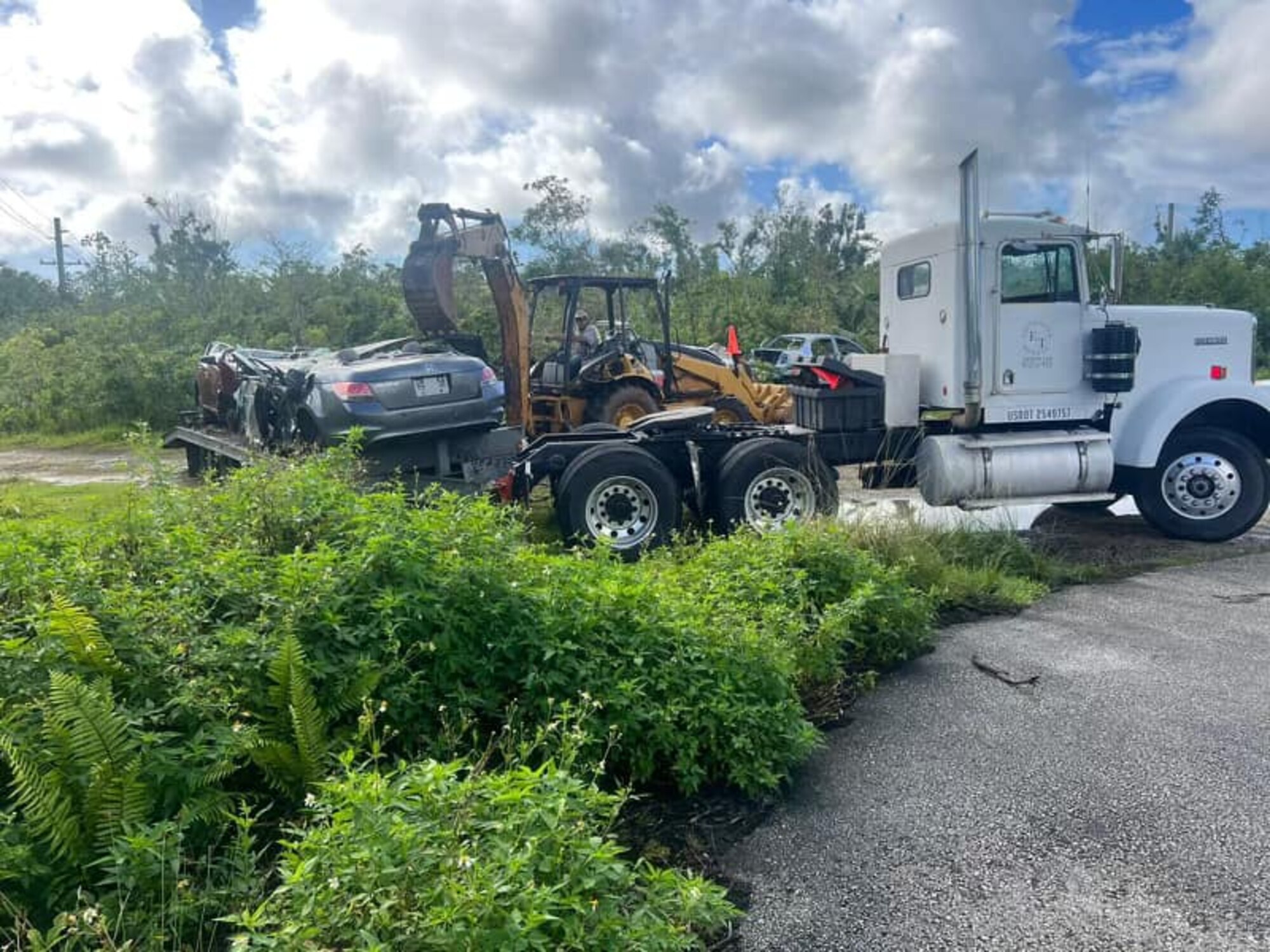 An abandoned vehicle is loaded on to a truck at Andersen Air Force Base, Guam, September 2023.