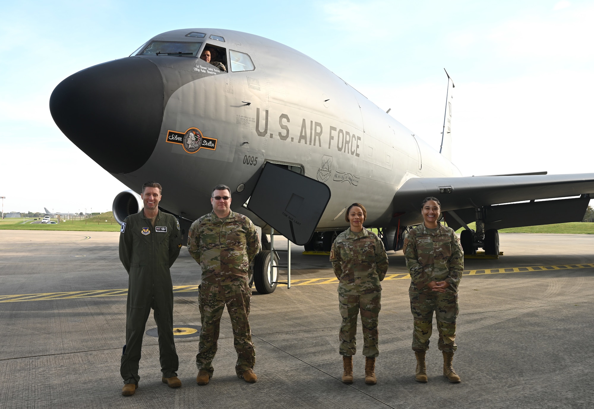 U.S. Air Force Col. Ryan Garlow, left, 100th Air Refueling Wing commander; Col. Thomas Hutton, second left, 100th Operations Group commander; Chief Master Sgt. Tiffany Griego, second right, 100th ARW command chief, and Chief Master Sgt. Wakisha Humphries, right, 100th Operations Group senior enlisted leader, show off the latest heritage nose art – “Silver Dollar” – on a KC-135 Stratotanker after a dedication ceremony at Royal Air Force Mildenhall, England, Oct. 10, 2023. Each of the 100th ARW’s tankers bears a heritage nose art, based on those painted on the side of B-17 Flying Fortress aircraft at the 100th Bomb Group during World War II, and “Silver Dollar” is the only double-sided design in the fleet. (U.S. Air Force photo by Karen Abeyasekere)