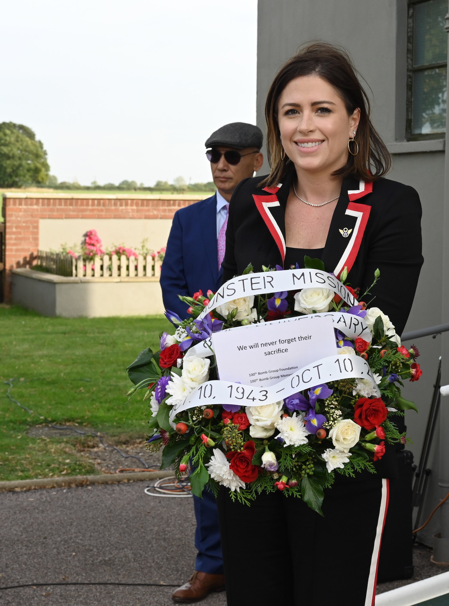Chloe Melas, granddaughter of Capt. Frank Murphy, World War II veteran and 100th Bomb Group navigator, prepares to lay a wreath in his honor near plaques on the wall of the control tower during a ceremony honoring the 80th anniversary of “Black Week” at the 100th BG Memorial Museum at Thorpe Abbotts, Norfolk, England, Oct. 10, 2023. Melas was over from New York to visit Royal Air Force Mildenhall and Thorpe Abbotts and share her grandfather’s story. (U.S. Air Force photo by Karen Abeyasekere)