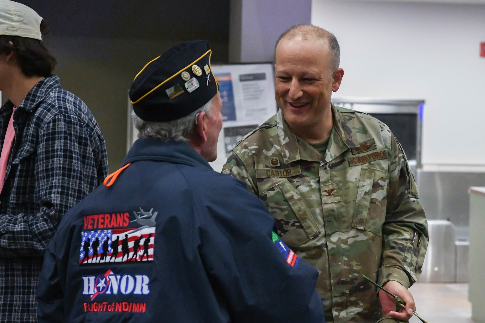 Veteran shakes hands with military member.