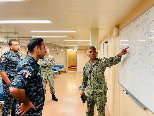 Senior Chief Hospital Corpsman Louie Bismonte, right, discuss a mass casualty drill with Egyptian doctors and nurses during Tactical Combat Casualty Care (TCCC) for exercise Bright Star 23 aboard ENS Anwar El-Sadat at Ras Al Tin Naval Forces Base, Egypt, Sept. 10.