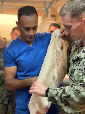 An Egyptian nurse and Hospital Corpsman 2nd Class Joseph Wanda, a command pay and personnel administrator assigned to U.S. Navy Medicine Readiness and Training Unit Bahrain, practice wrapping a bandage during a Tactical Combat Casualty Care (TCCC) course for exercise Bright Star 23 aboard Egyptian Naval Ship (ENS) Anwar El-Sadat at Ras Al Tin Naval Forces Base, Egypt, Sept. 11.