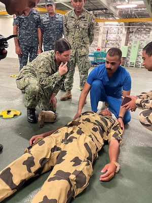 Lt j.g. Anna Walker, a staff nurse assigned to U.S. Navy Medicine Readiness and Training Unit Bahrain, and an Egyptian nurse evaluate a patient during a mass casualty drill for exercise Bright Star 23 aboard Egyptian Naval Ship (ENS) Anwar El-Sadat at Ras Al Tin Naval Forces Base, Egypt, Sept. 12.