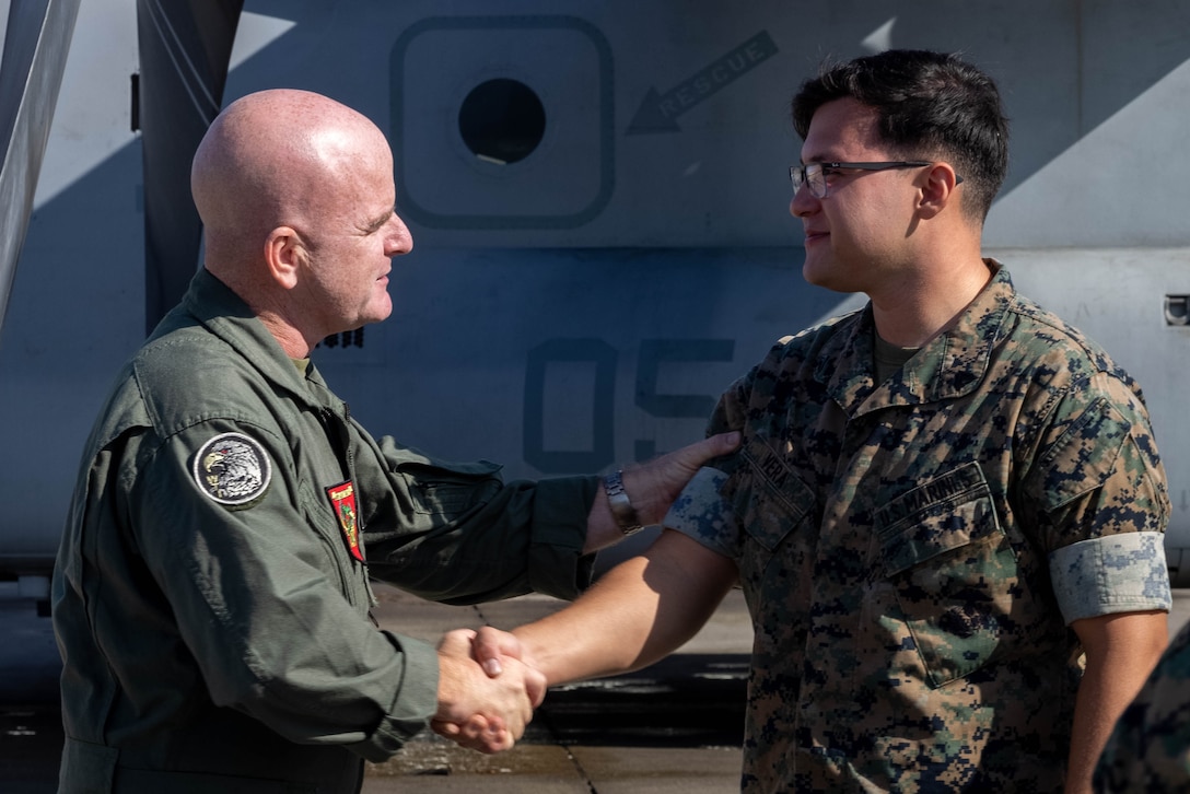 U.S. Marine Corps Col. Kevin Hunter, commanding officer of Marine Aircraft Group 16, 3rd Marine Aircraft Wing, congratulates Cpl. Gabriel Vera, a helicopter mechanic with Marine Heavy Helicopter Squadron (HMH) 462, MAG-16, during a re-enlistment gathering at Marine Corps Air Station Miramar, California, Oct. 18, 2023.  MAG-16 is exceeding the fiscal year 2024 retention mission by reenlisting 62 Marines. The retention of the best and most qualified Marines is vital for shaping and sustaining the Marine Corps as an elite fighting force. (U.S. Marine Corps photo by Lance Cpl. Jennifer Sanchez)