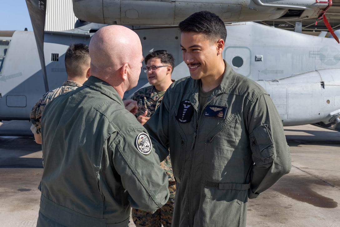 U.S. Marine Corps Col. Kevin Hunter, commanding officer of Marine Aircraft Group 16, 3rd Marine Aircraft Wing, congratulates Staff Sgt. Christian Puga, a helicopter mechanic with Marine Heavy Helicopter Squadron (HMH) 462, MAG-16, during a re-enlistment gathering at Marine Corps Air Station Miramar, California, Oct. 18, 2023.  MAG-16 is exceeding the fiscal year 2024 retention mission by reenlisting 62 Marines. The retention of the best and most qualified Marines is vital for shaping and sustaining the Marine Corps as an elite fighting force. (U.S. Marine Corps photo by Lance Cpl. Jennifer Sanchez)