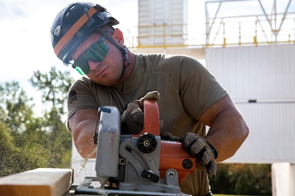 A member of the Oklahoma National Guard’s 63rd Civil Support Team, Sgt. 1st Class Corey Simmons, constructs a solid sole raker that would hold a wall in place when damaged, during a collapsed building exercise at the Edmond Fire Training Center, Edmond, Oklahoma, October 4, 2023. This simulation is part of a biennial weeklong operational readiness exercise, designed to ensure local first responders maintain preparedness and familiarity with one another. (Oklahoma National Guard photo by Staff Sgt. Reece Heck)