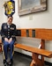Woman in Army uniform poses on a bench
