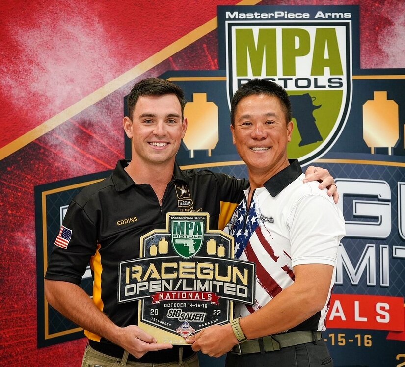 Two men stand posing with a plaque for the RaceGun Open/Limited Nationals