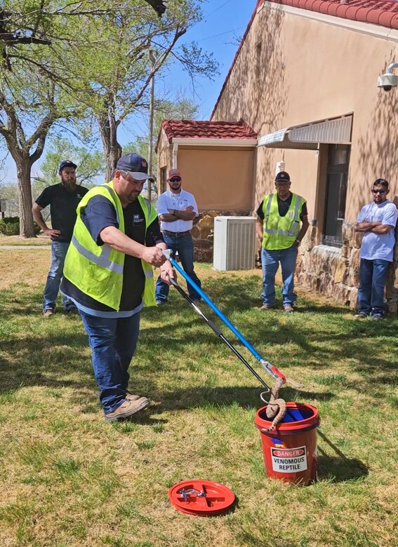 Job Licano, maintenance technician at John Martin Reservoir demonstrates how to safely move a rattlesnake during the training, May 4, 2023.