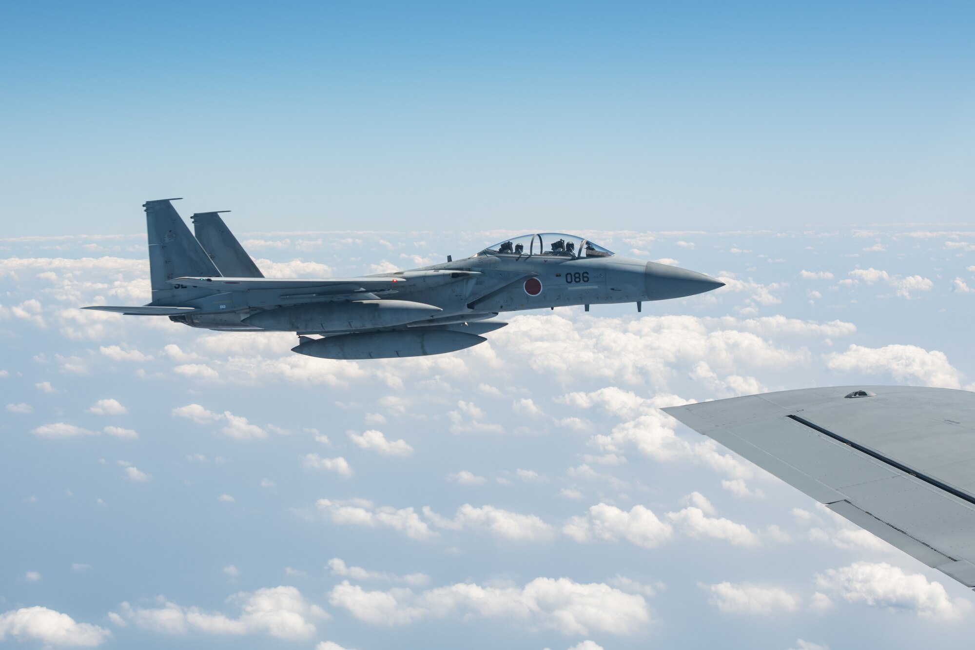 An aircraft flies off the wing of another aircraft.