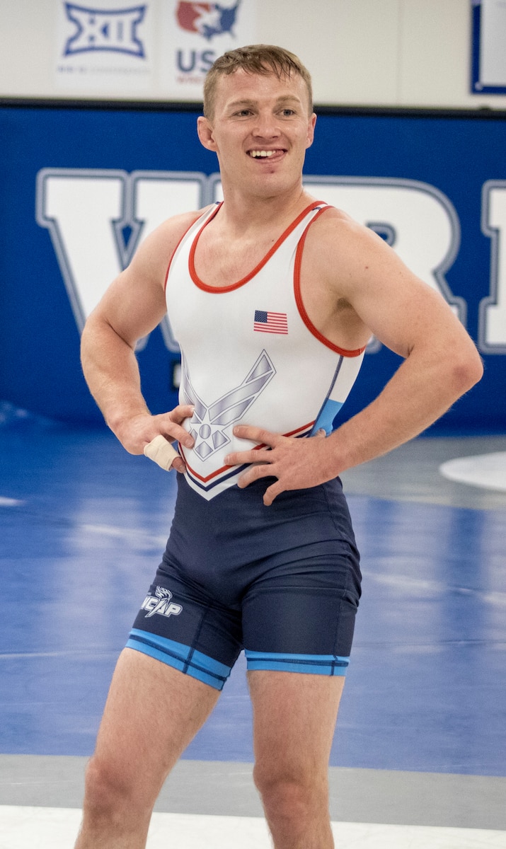 Brown standing with hands on hips looking off camera