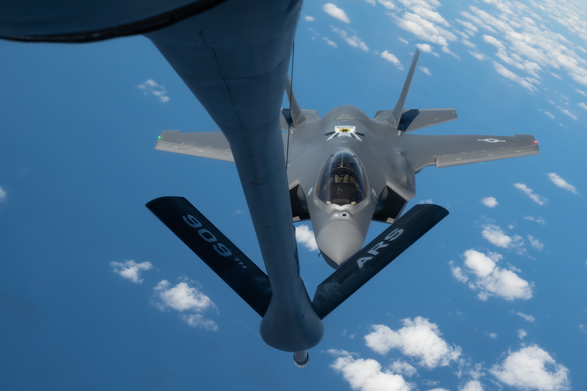 An aircraft approaches an aerial refueling boom.