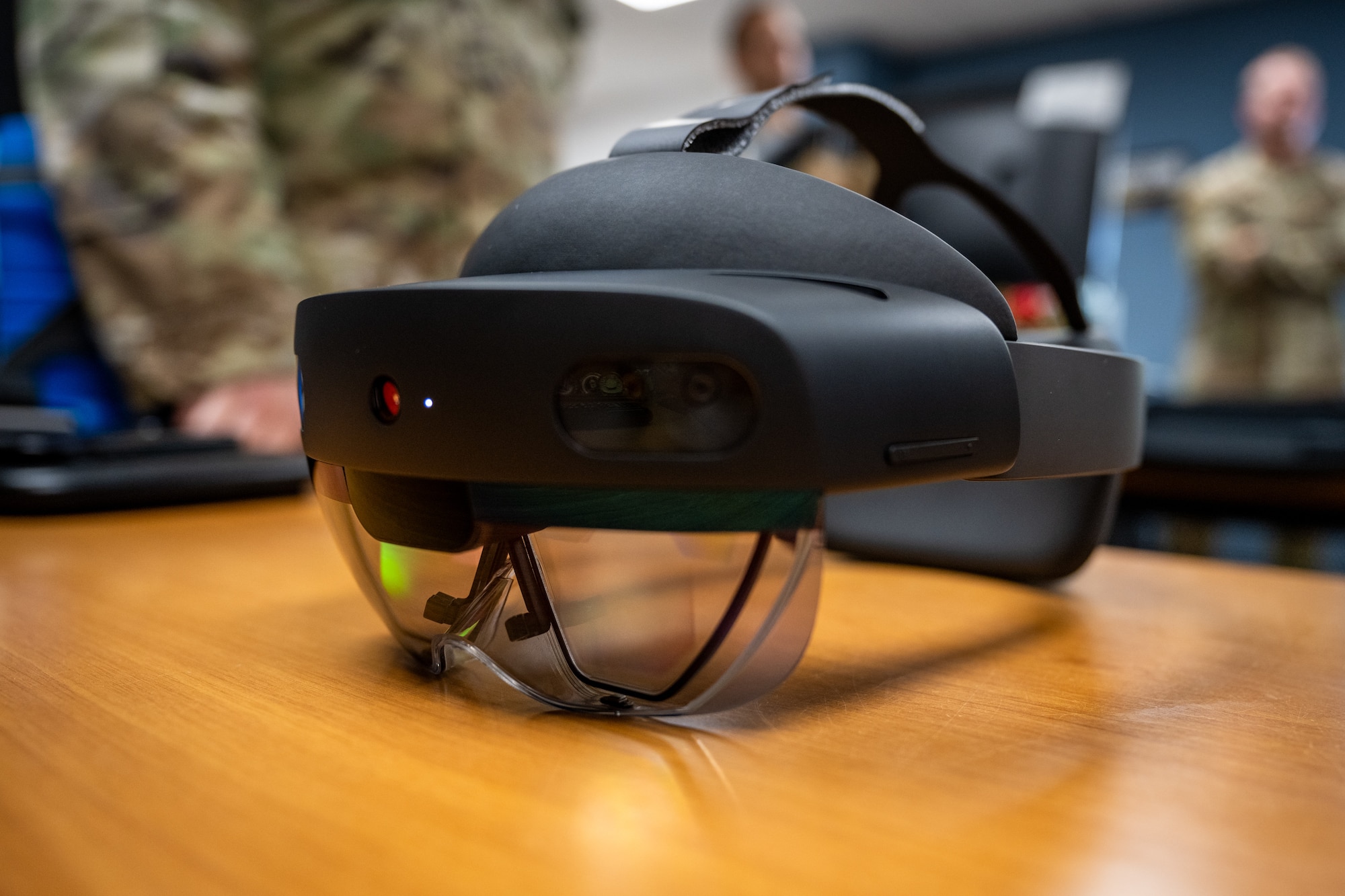 A black headset sits on a table with green and red lights on it