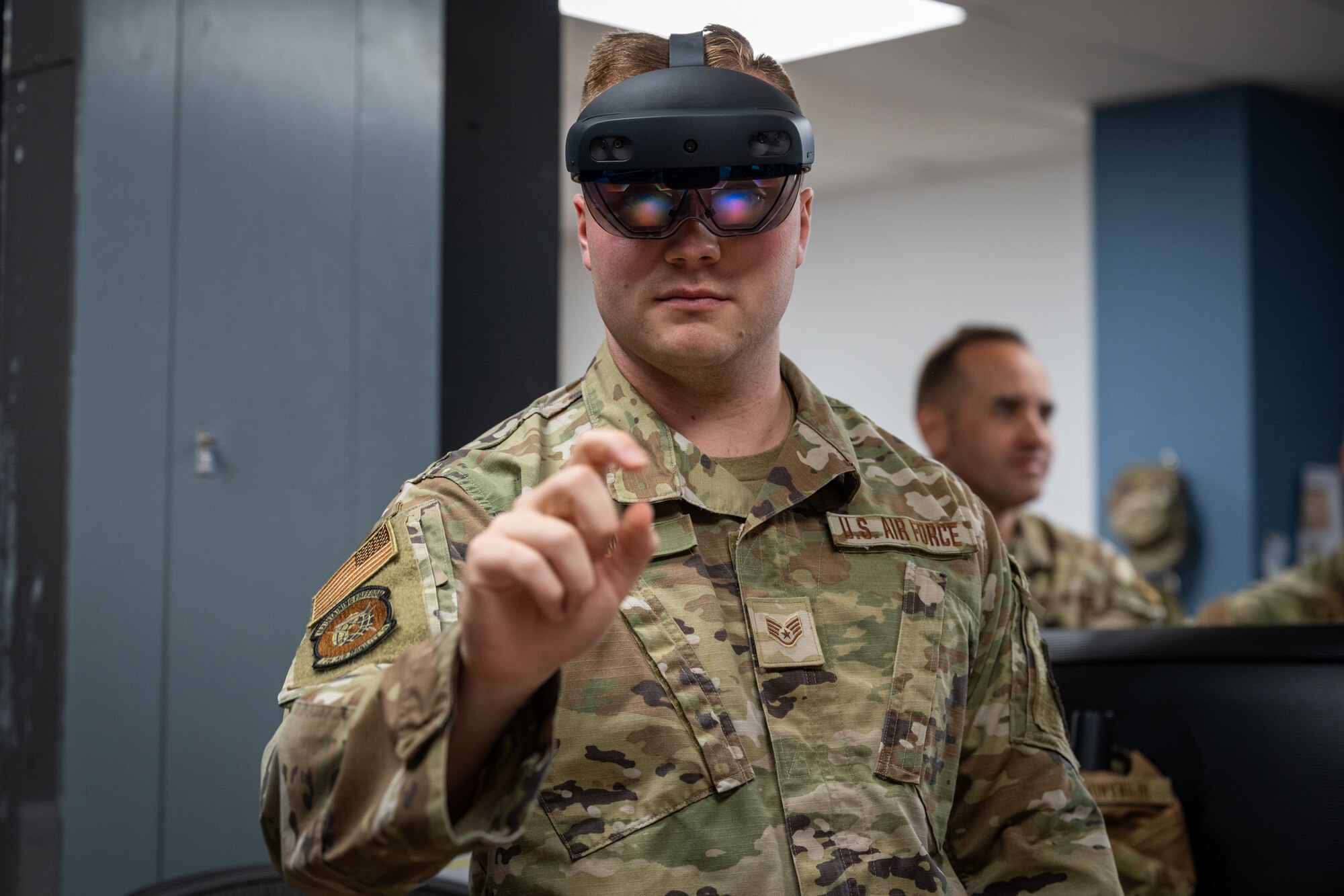A man in a VR headset reaches out his finger to interact with something on his feed
