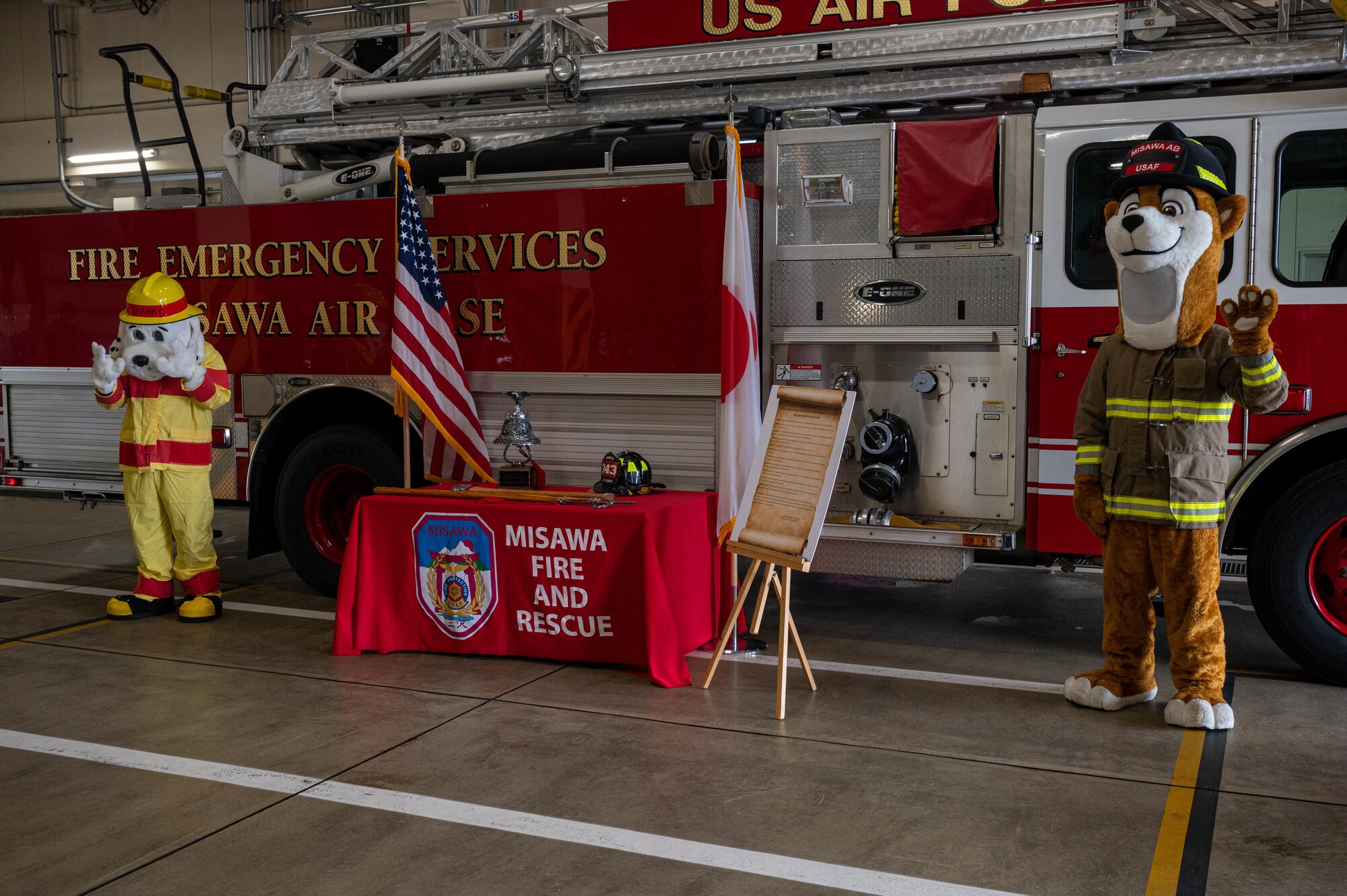 Team Misawa’s Fire Emergency Services mascots pose next to a Fire Prevention Proclamation at Misawa Air Base, Japan, Oct. 5, 2023.