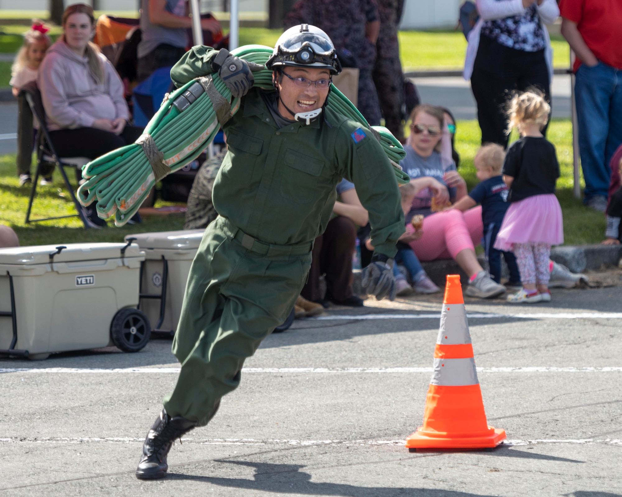 A member of the Japanese Air Self-Defense Force (JASDF) Fire Rescue team carries a fire hose during the annual Fire Prevention Week Fire Muster competition at Misawa Air Base, Japan, Oct. 12, 2023.