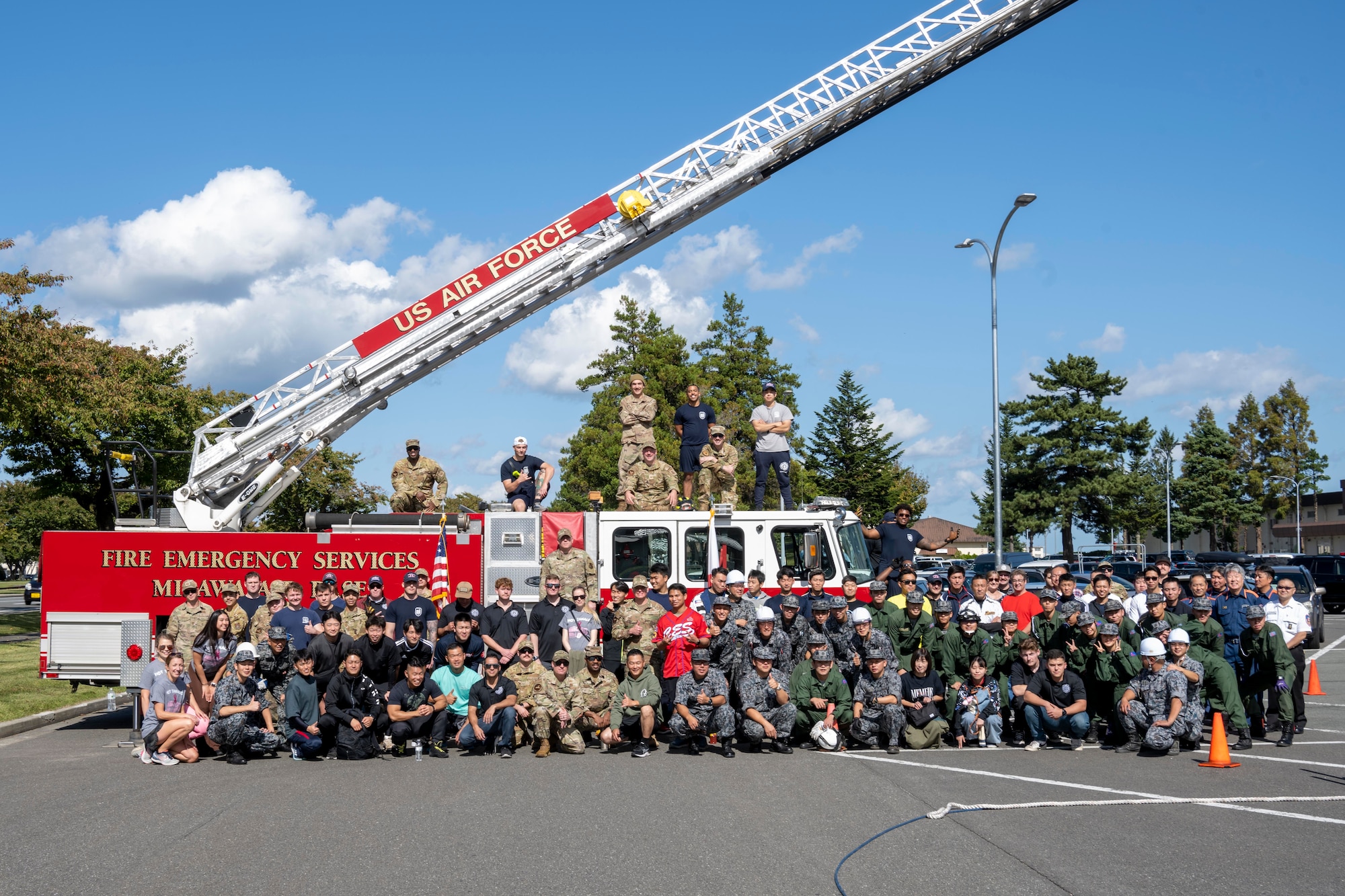 Participants pose in front of a firetruck during the annual Fire Prevention Week Fire Muster competition at Misawa Air Base, Japan, Oct. 12, 2023.