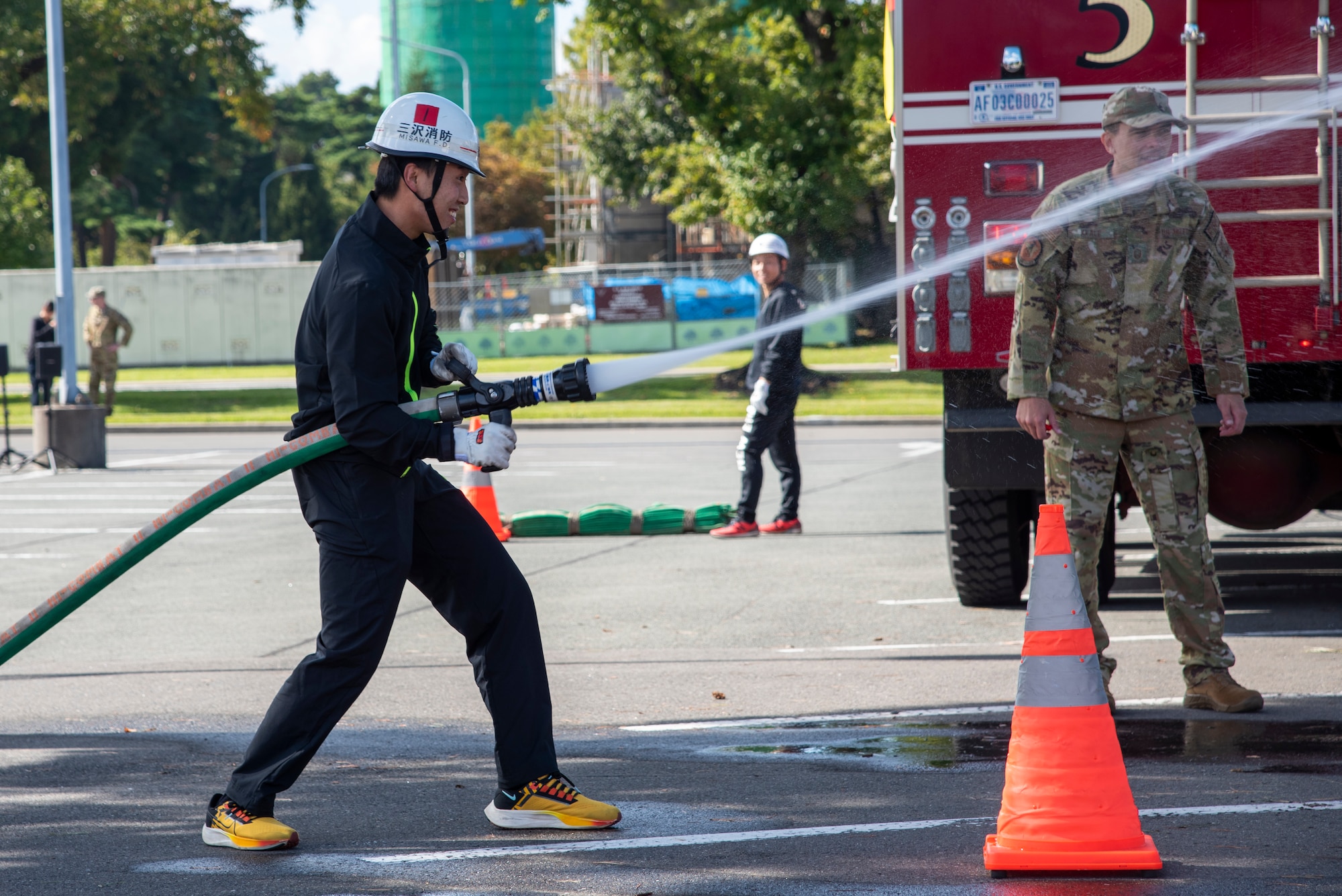 A member of Misawa City Fire Department sprays and demonstrates a water hose during the Misawa Air Base Fire Muster event at Misawa Air Base, Japan, Oct. 12, 2023.