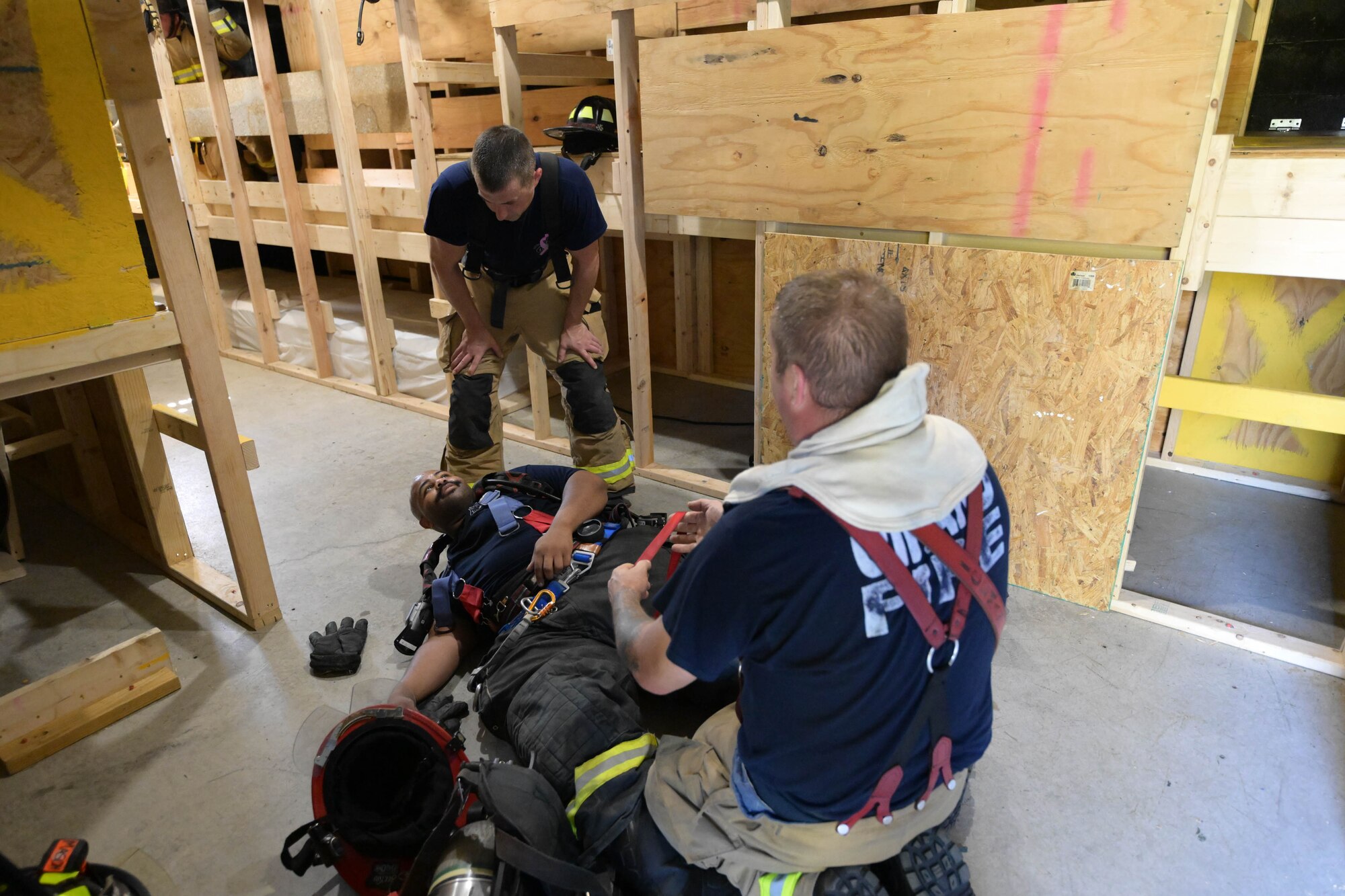 Ron Womack and Bryan Iceman, firefighters with the Girard Fire Department, discuss methods for moving downed firefighters out of harm's way with  Youngstown Air Reserve Station, Ohio, firefighter Anthony Mason, Oct. 3, 2023, during a joint training event here.