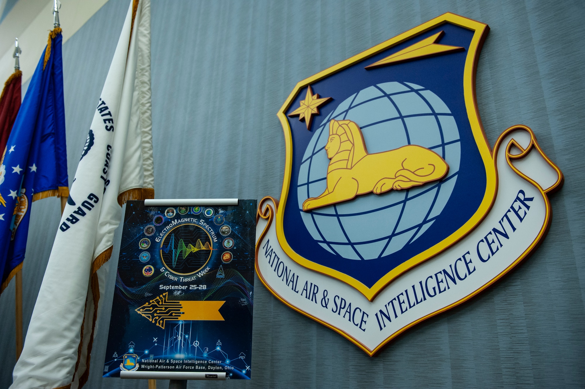 An Electromagnetic Spectrum and Cyber Threat Week poster is displayed near the entrance to the auditorium at the National Air and Space Intelligence Center, Wright-Patterson Air Force Base, Ohio, Sept. 25, 2023. The week-long event was designed to enhance joint force readiness in electromagnetic spectrum operations and cyber capabilities.