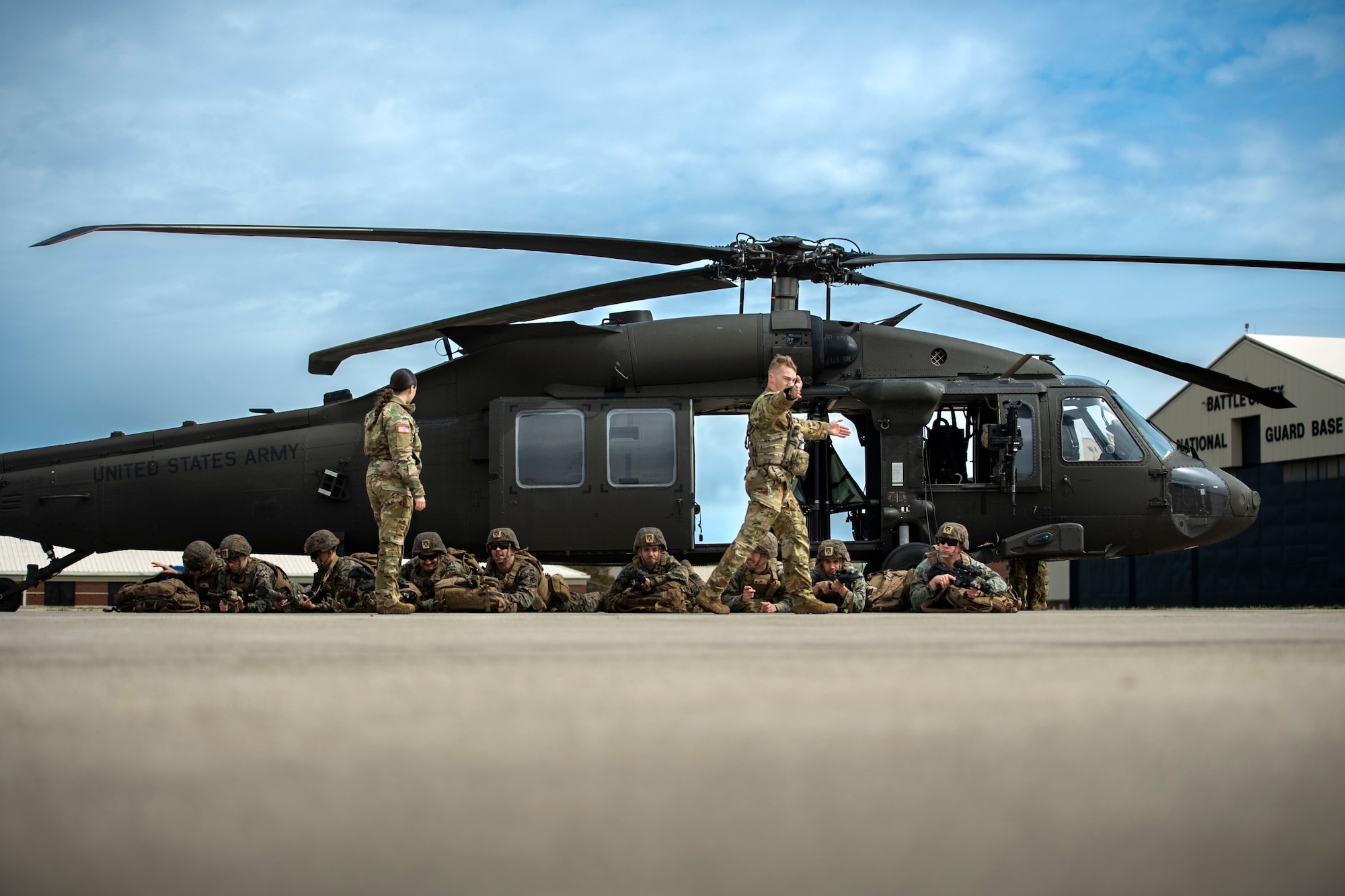 Sgt. Cody Rambo, a crew chief attached to the Company B, 147th Aviation Regiment, Grand Ledge Armory, delivers passenger briefs to Marines and instructs them in entering and exiting procedures at the Battle Creek Air National Guard Base (BCANGB), Battle Creek, Mich., May 6, 2023. Seven Army UH-60 Blackhawks transported Marines, assigned to the 1st Battalion, 24th Marines Regiment, from BCANGB to Camp Grayling, as a part of a joint platoon live-fire exercise.