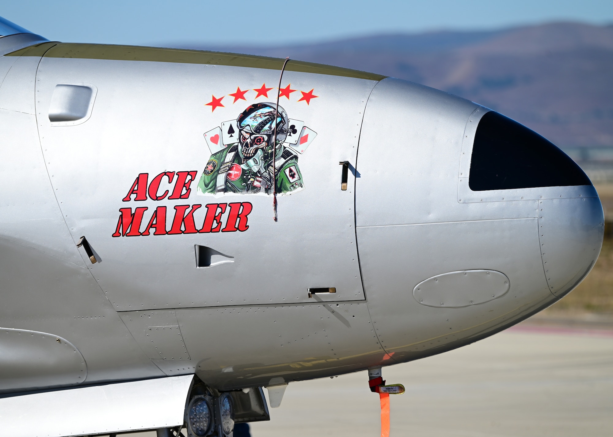 A vintage jet trainer is staged on a runway.