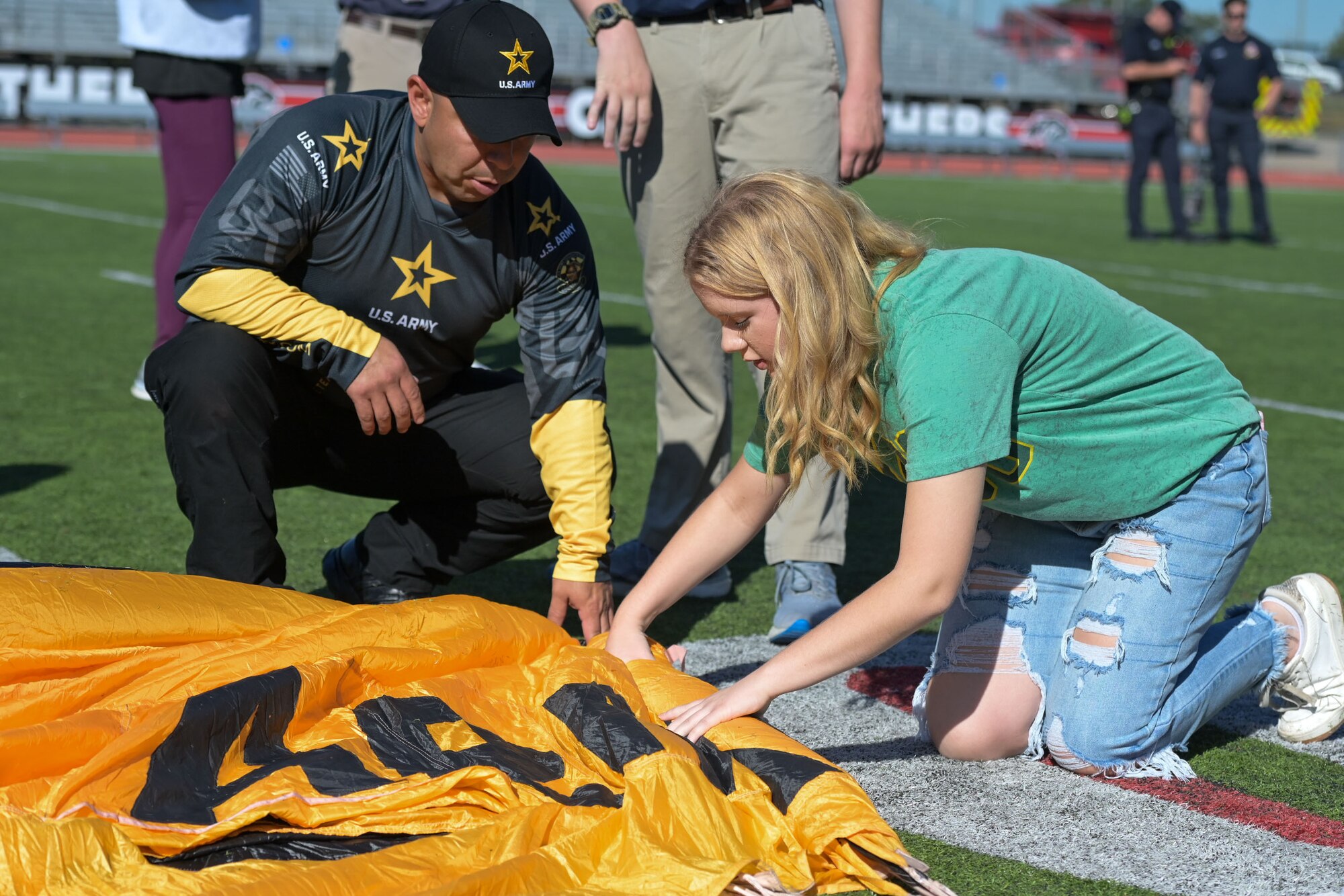 Golden Knight teaches student how to fold a parachute.