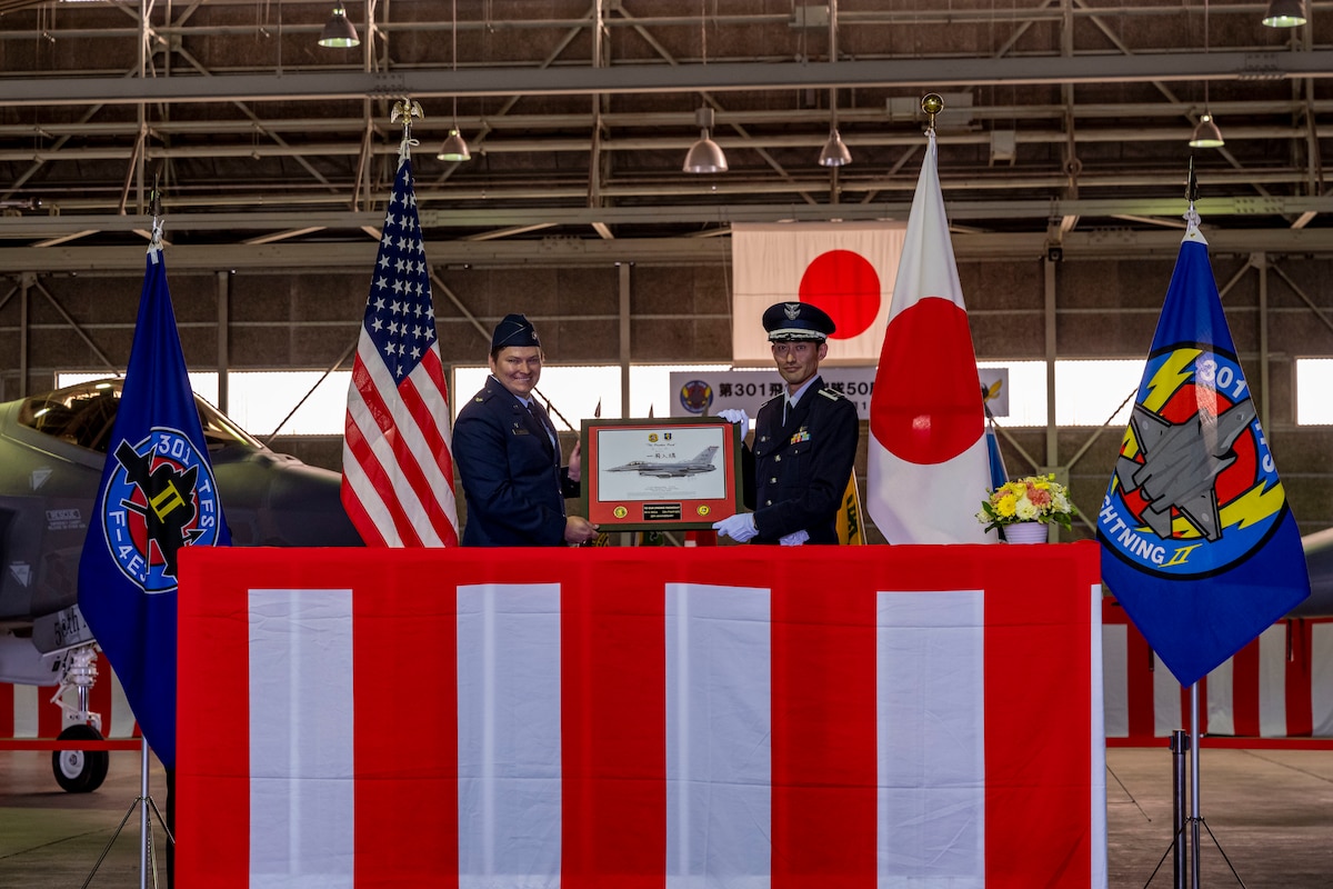 U.S. Air Force Lt. Col. Keegan Dale, 13th Fighter Squadron commander, and Japan Air Self-Defense Force Lt. Col. Kazuhito Okamoto, 301st Tactical Fighter Squadron commander, exchange gifts after formally establishing sister squadrons relationship at Misawa Air Base, Japan, Oct 14, 2023.