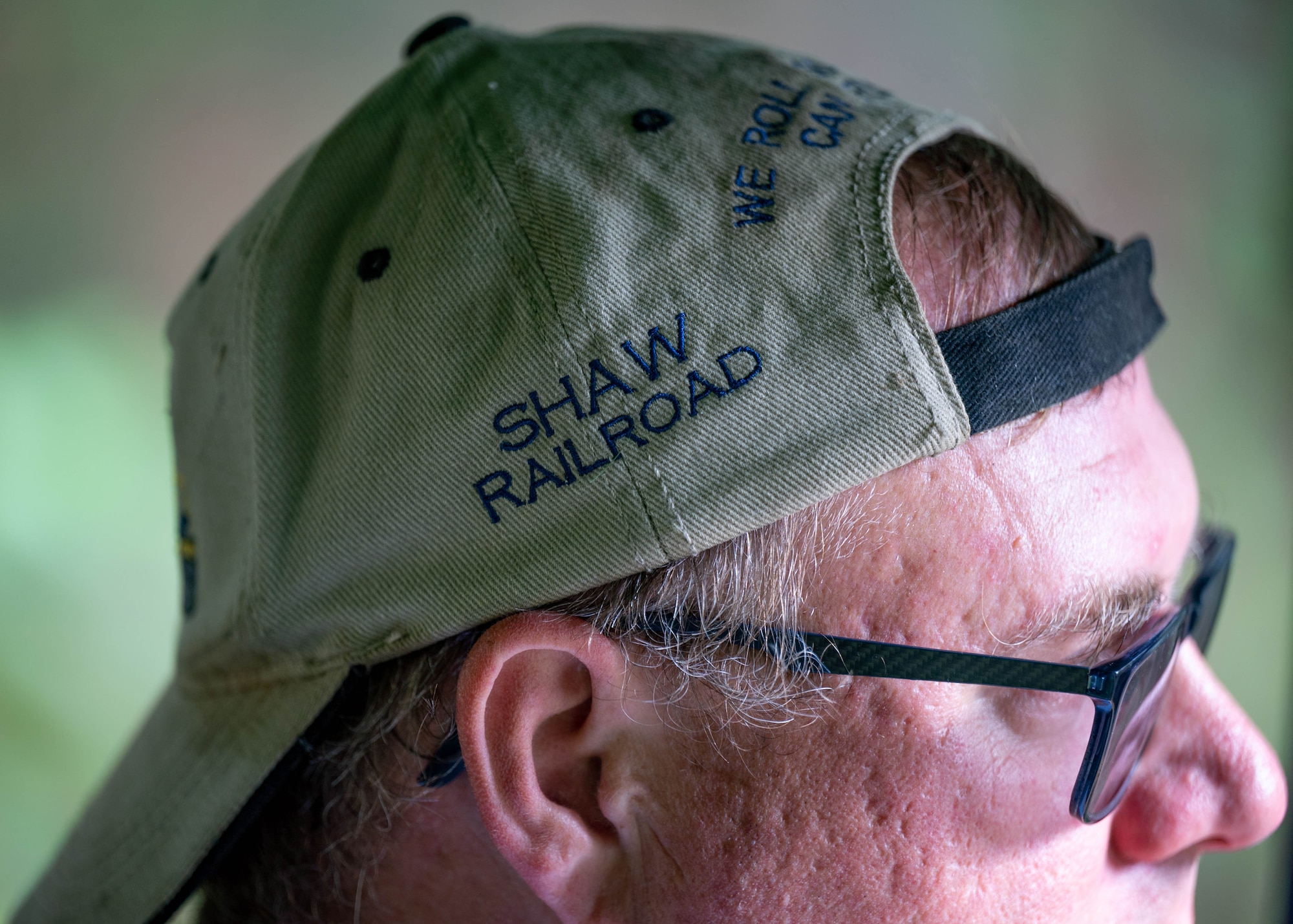 Man wearing a customized hat with the words "Shaw Railroad" embroidered.