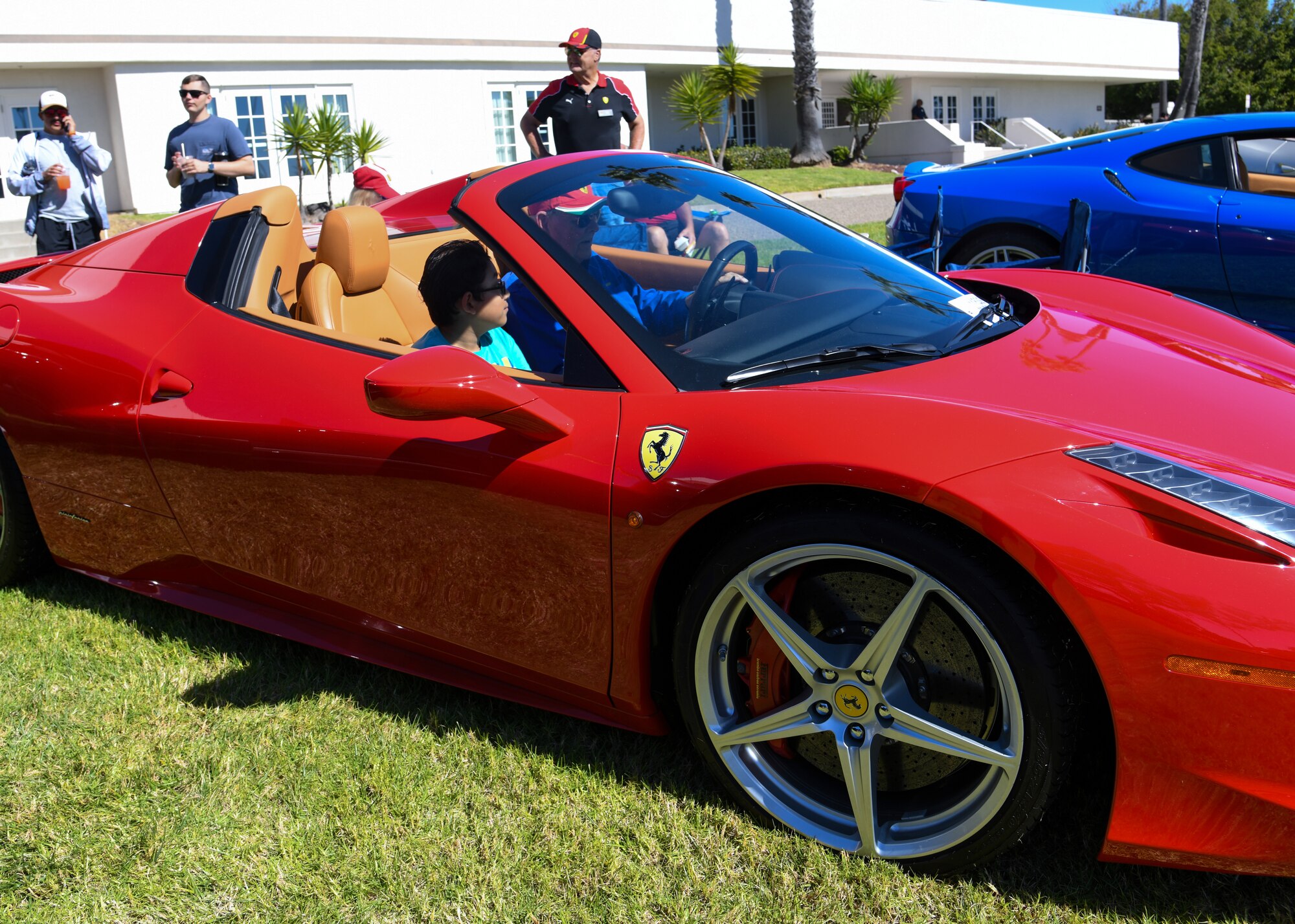 A member of the Ferrari Club show cases his vehicle up close to a child of a military service member at Vandenberg Space Force Base, Calif., Oct. 16, 2023.