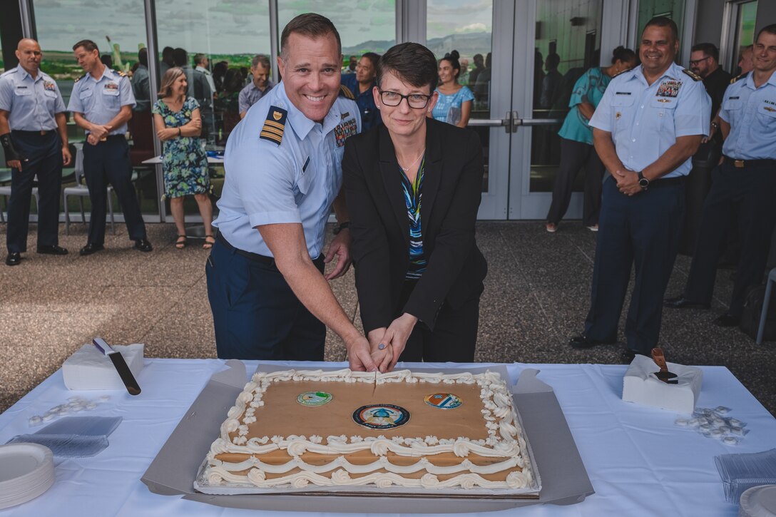 Coast Guard members cut a cake for ribbon cutting ceremony. Coast Guard stands up new marine environmental response unit in Honolulu.