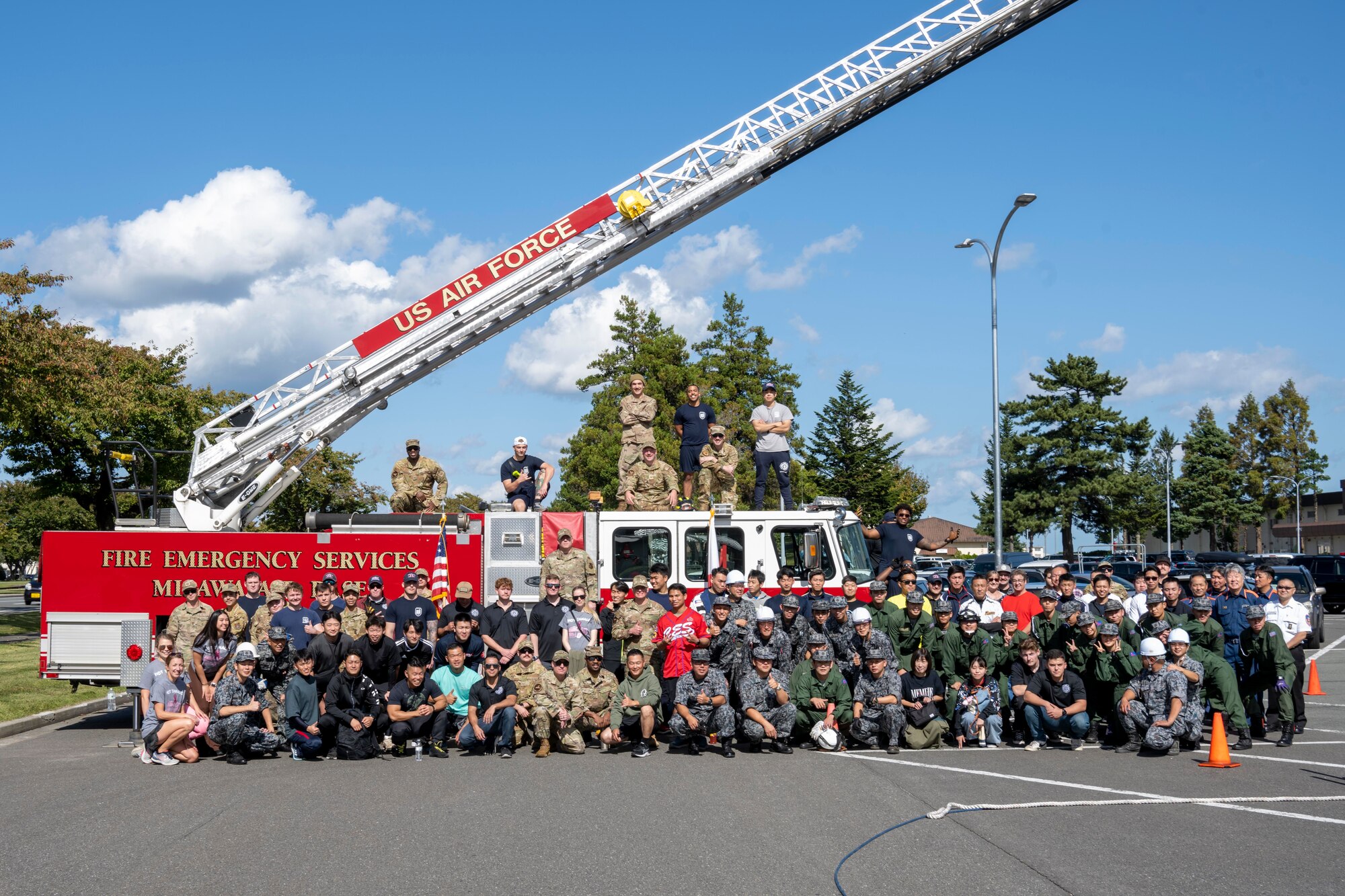 Participants pose in front of a firetruck during the annual Fire Prevention Week Fire Muster competition at Misawa Air Base, Japan, Oct. 12, 2023.