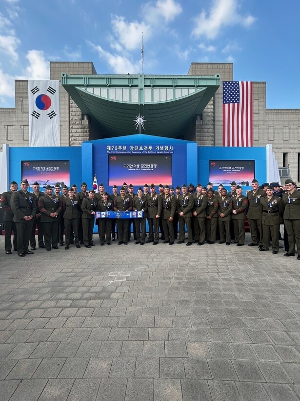 Members of U.S. Marine Corps Forces Korea pose in front of the stage following the 73rd Commemoration of the Battle of the Chosin Reservoir. The commemoration was held in order to remember those who fought during the battle, the sacrifices they made, and the alliance that was forged in the battle's aftermath.