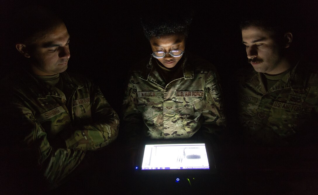 Senior Airman Kevin Sinning, Airman 1st Class Ariana Nalica and Senior Airman James Verrelli, 436th Civil Engineer Squadron explosive ordnance disposal technicians, look at the X-ray of an improvised explosive device