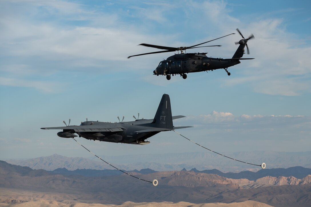 An HH-60W Jolly Green II and HC-130J Combat King II assigned to the 34th Weapons School perform a flyover over Las Vegas, Nev.