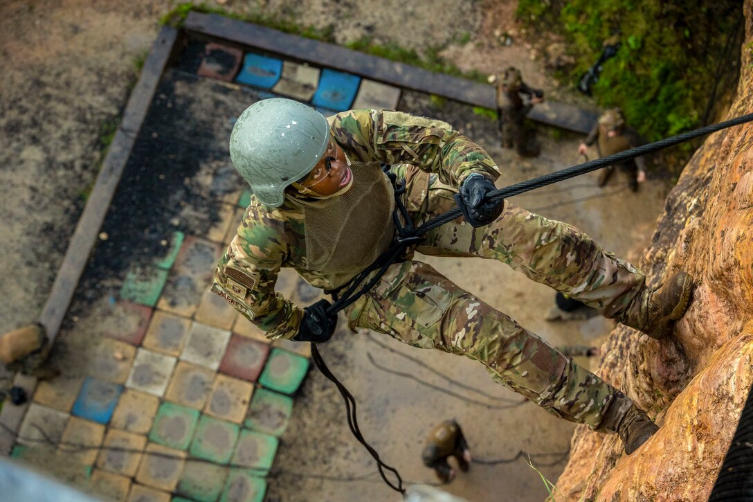 U.S. Air Force Master Sgt. Nicole Jarrett, religious affairs specialist, repels down a rock wall
