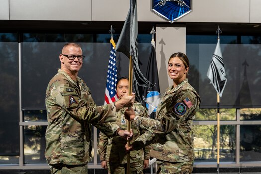  Two military members pass a guidon