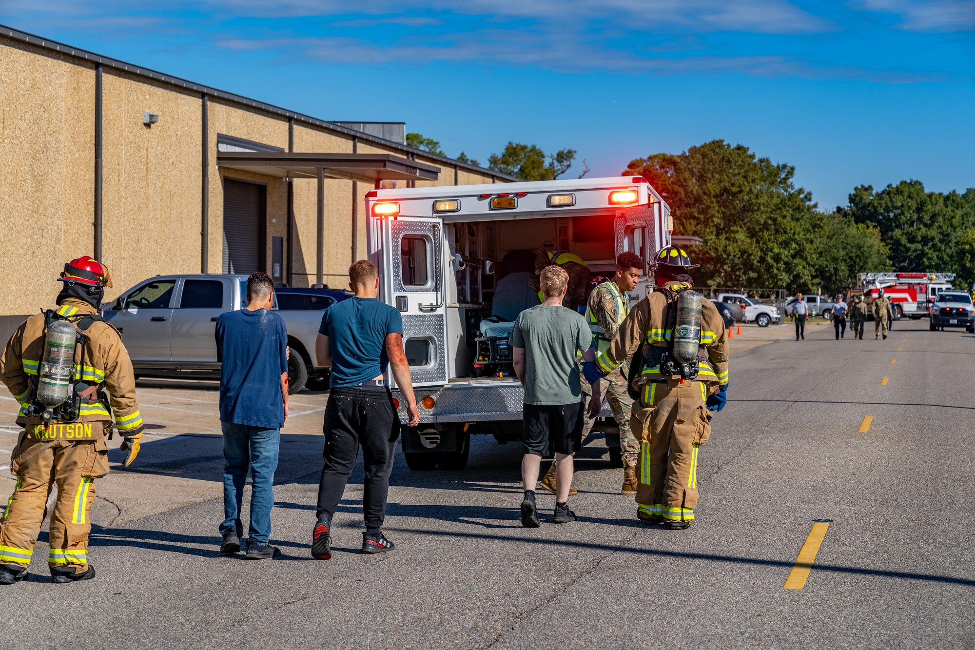 U.S. Airmen are escorted to an ambulance by Keesler firefighters during a training exercise at Keesler Air Force Base, Mississippi, Oct. 19, 2023.