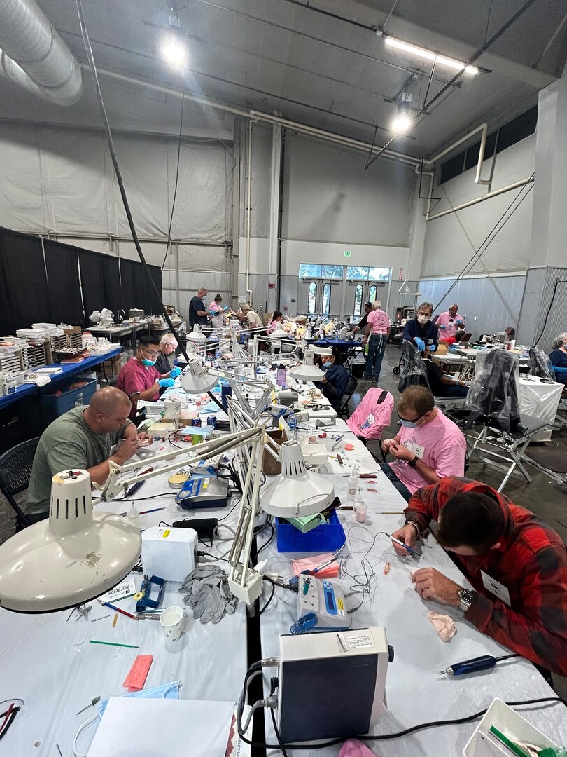 Individuals making dental prosthetics at dental clinic.