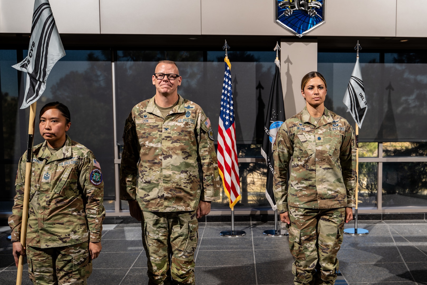 three military members stand at attention