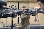 Soldier works on piece of gear.