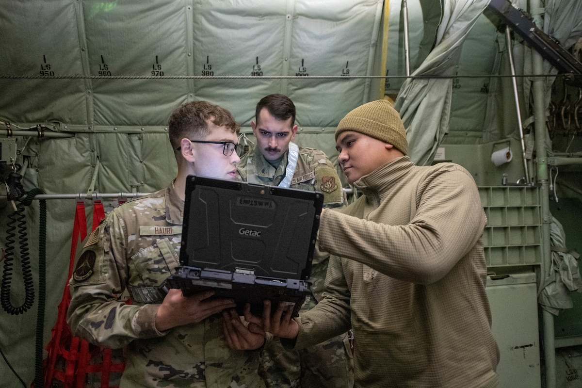 Airmen work a pre-flight inspection on an aircraft.