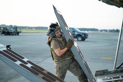 An Airman lowers a loading ramp on an aircraft