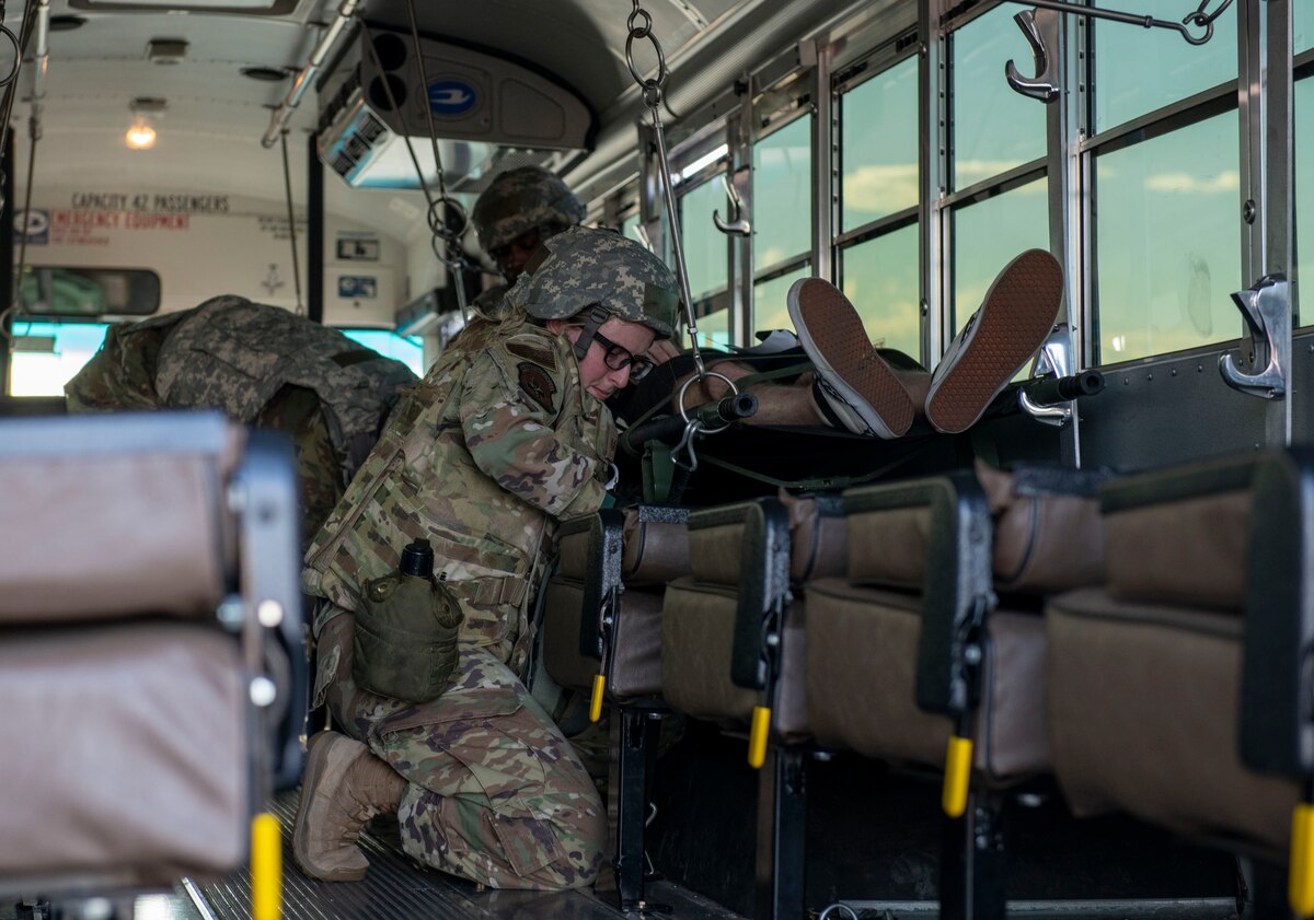 An Airman straps a simulated patient into a medical transport vehicle
