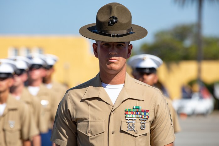 A U.S. Marine Corps drill instructor with India Company, 3rd Recruit Training Battalion, stands in front of his platoon during a graduation ceremony at Marine Corps Recruit Depot San Diego, Oct. 20, 2023. Graduation took place at the completion of the 13-week transformation, which included training for drill, marksmanship, basic combat skills, and Marine Corps customs and traditions. (U.S. Marine Corps Photo by Lance Cpl. Sarah M. Grawcock)